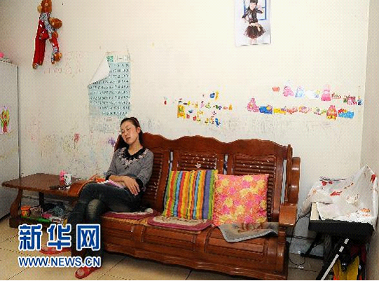 10月12日，税成康的妻子张亚霞在家中休息。参加工作13年，税成康一家仍住在一幢老旧的楼房里，70多平方米的屋子里，是最普通的木质沙发、上了年头的彩电、斑驳暗淡的墙面……