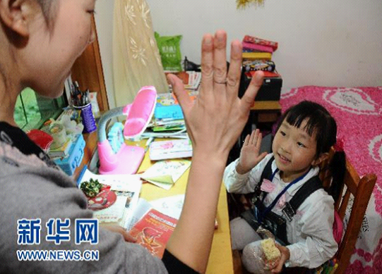 10月12日，张亚霞正在击掌鼓励女儿税忆宁（右）好好学习。6岁的女儿是税成康的心肝宝贝，如今更是张亚霞的精神支柱。