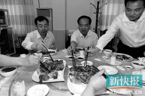 ■林少春（中）在汕尾市政府机关食堂吃工作餐时带头吃鸡。南方日报供图